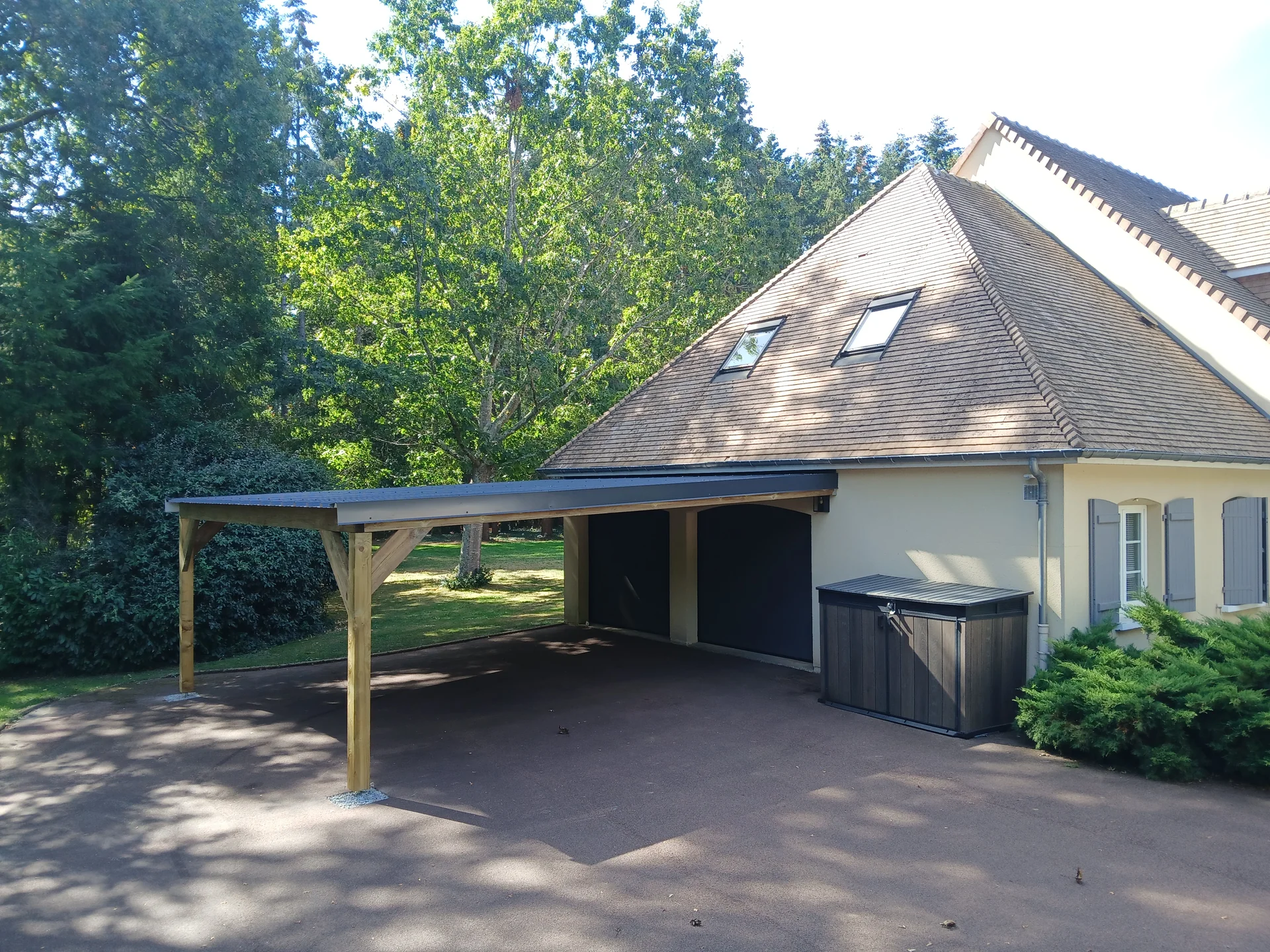 Carport en bois adossé à une maison, vue d’ensemble