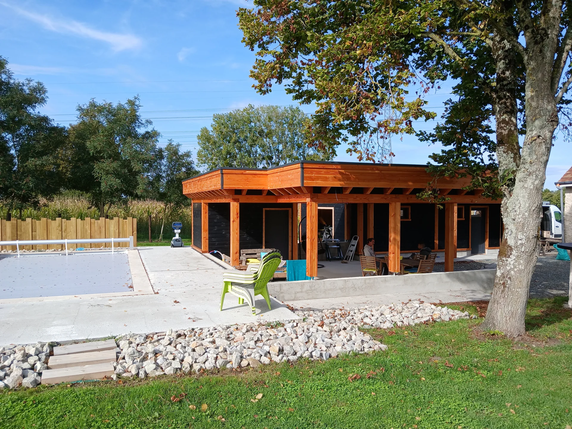 Construction en bois avec terrasse couverte, vue depuis le jardin